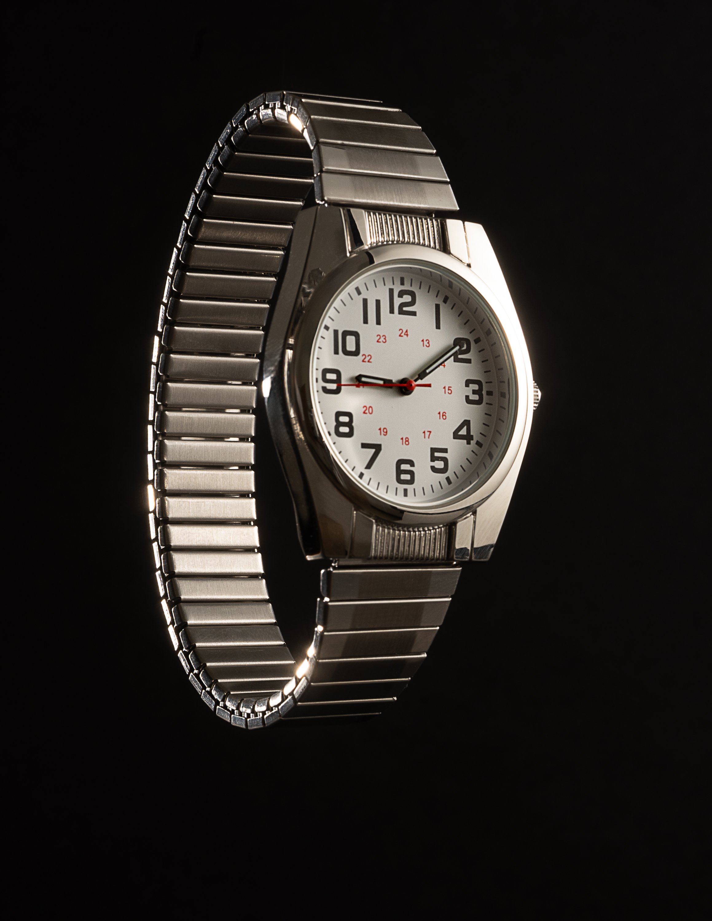 A silver wristwatch with a metallic band, showing the time as 1:45 and 47 seconds, against a black background.